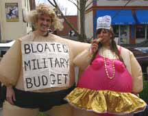 two war tax resisters in “fat suits”, one labeled “Bloated Military Budget”