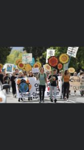 young people marching with signs, banners and smiles