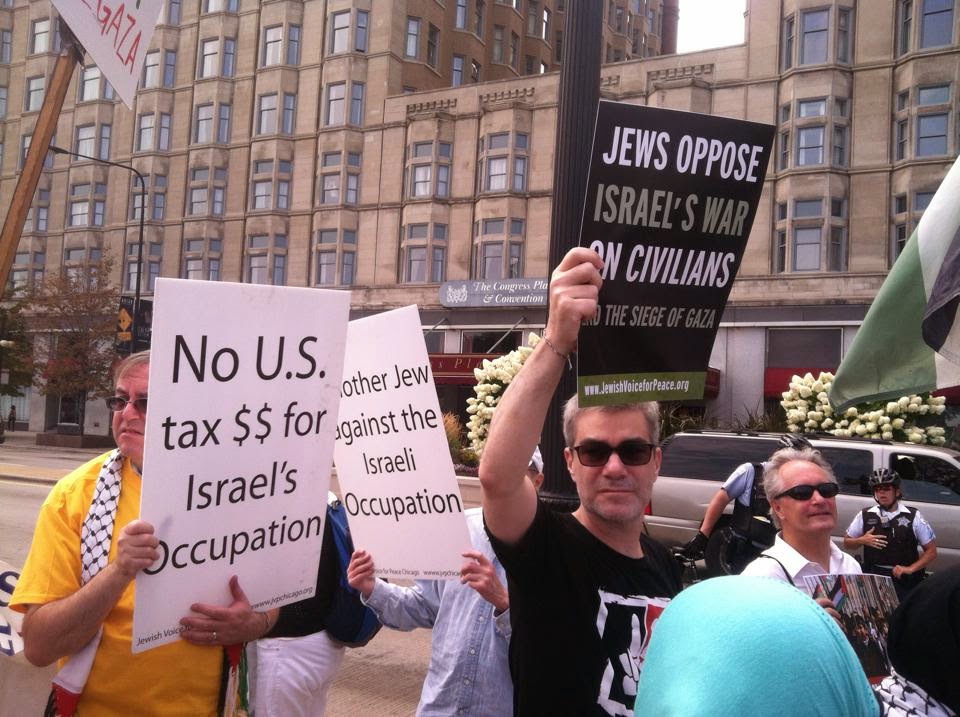 photo of several protesters on a sidewalk holding signs