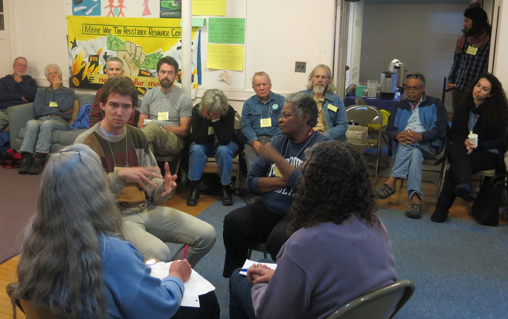 A fish bowl exercise at the New Englanf GAthering. Pictured are NWTRCC field organizer Sam Koplinka-Loehr speaking, and (clockwise) Mandy Carter, Mary Regan, and Joanne Sheehan with backs to camera. Photo by Ruth Benn