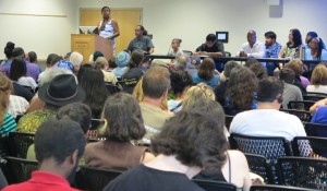 shot from the audience looking up at a podium and panel of speakers