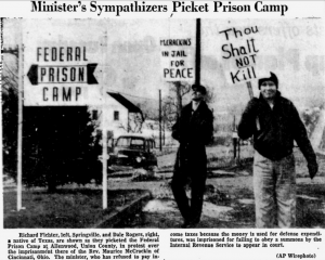 Richard Fichter, left, Springville, and Dale Rogers, right, a native of Texas, are shown as they picketed the Federal Prison Camp at Allenwood, Union County, in protest over the imprisonment there of the Rev. Maurice McCrackin of Cincinnati, Ohio. The minister, who has refused to pay income taxes because the money is used for defense expenditures, was imprisoned for failing to obey a summons by the Internal Revenue Service to appear in court.